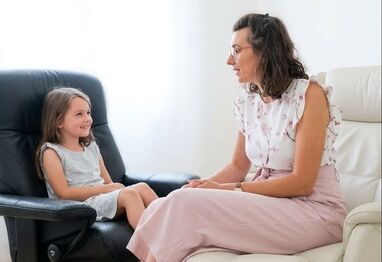 Kinderhypnose Basel. Einfühlsame Hypnose Therapeutin während Hypnose mit einem Kind.